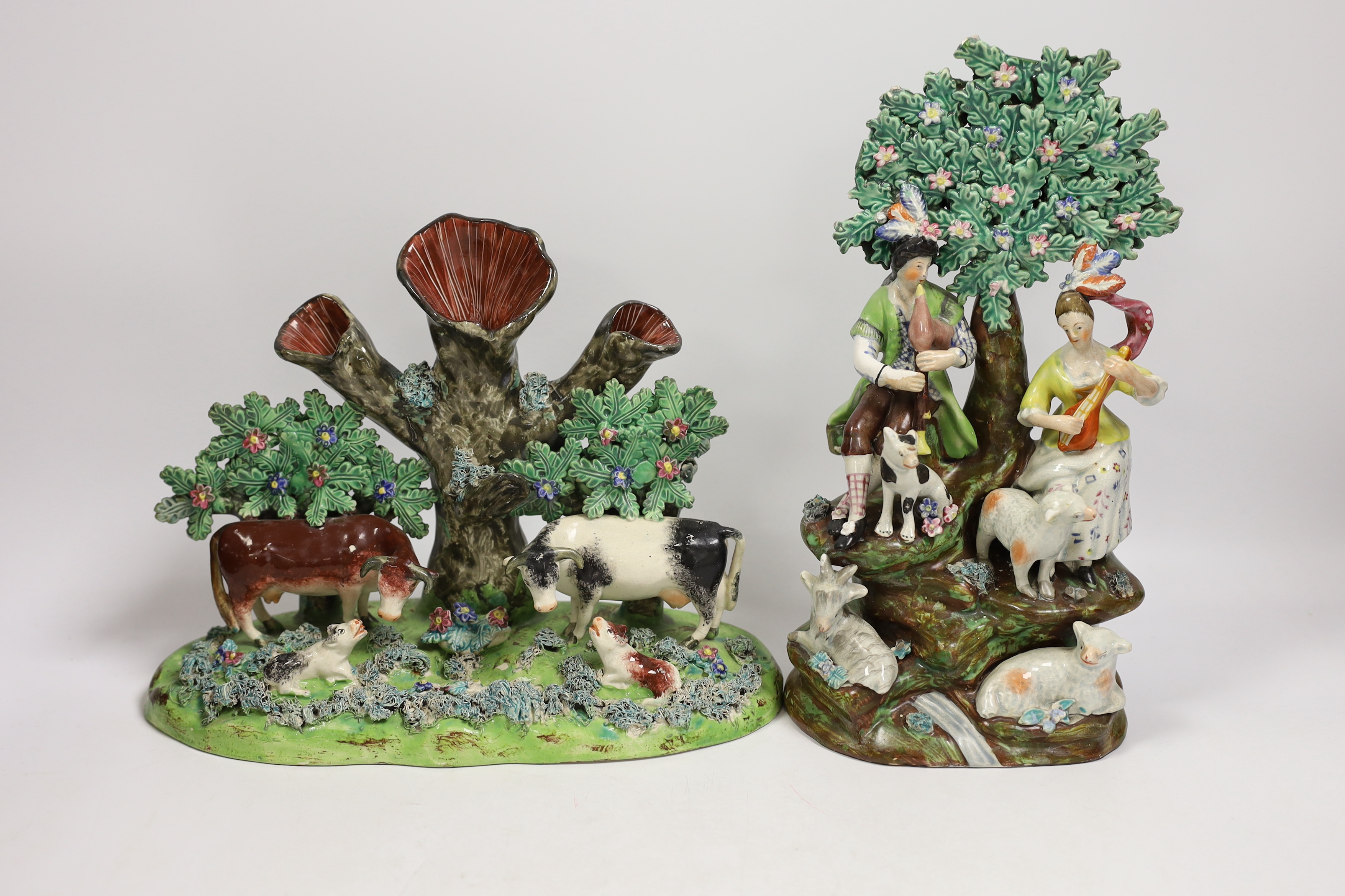 Four 19th century Staffordshire figurative groups; two musicians with sheep, etc. cows with calves group, and a pair of sheep and ram stamped ‘salt’, tallest 27cm